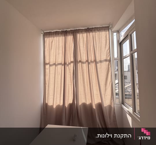 חדר עם וילון, שולחן ומסמך על השולחן
